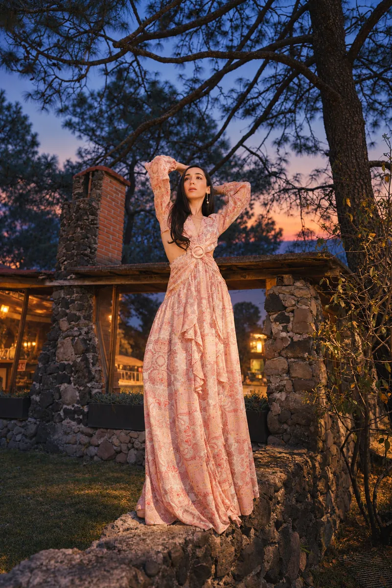 A woman in a spring dress under the trees at dusk