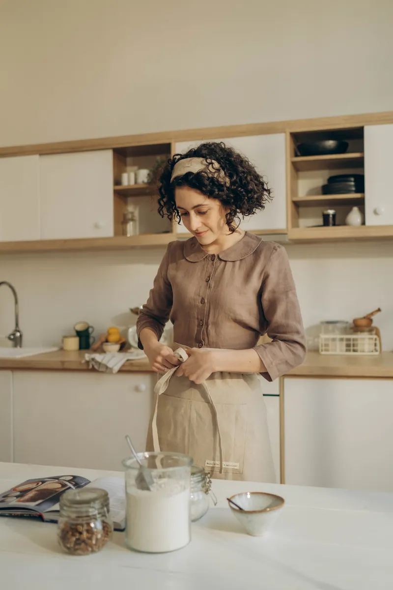 A woman baking in a dim kitchen